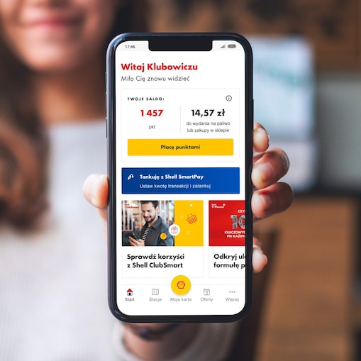 Zdjęcie przedstawiające zadowolona kobietę pokazującą aplikację Shell ClubSmart w telefonie