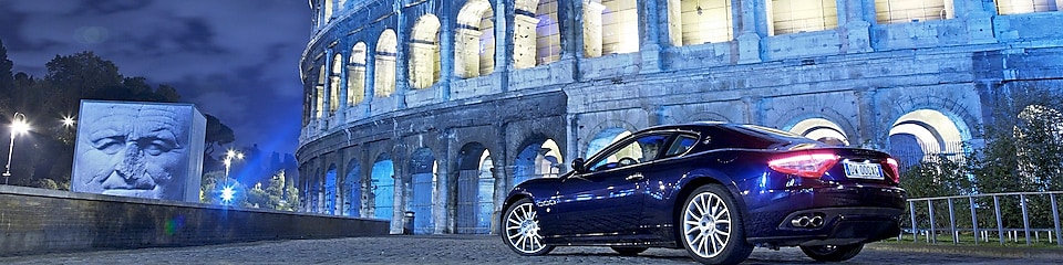Samochód zaparkowany nocą przed Koloseum w Rzymie