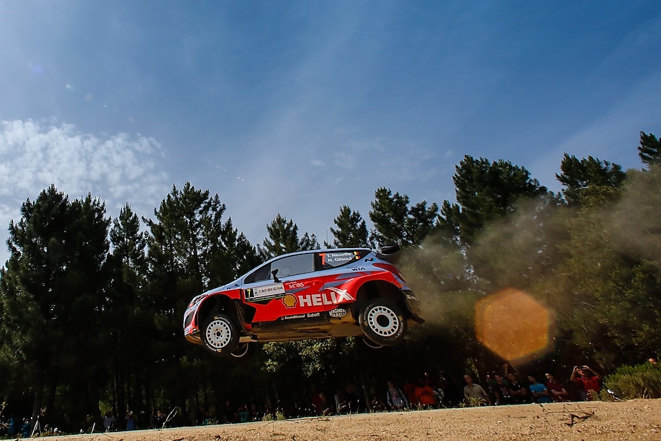 Przelatujący w powietrzu samochód zespołu Hyundai Shell na Rajdowe Samochodowe Mistrzostwa Świata