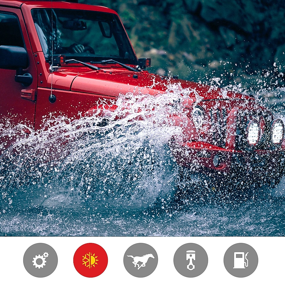 Czerwony Jeep z pluskiem przejeżdża przez koryto rzeki, pokazując zalety wydajnego w skrajnych temperaturach produktu.