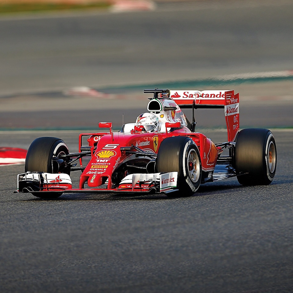 Czerwone Scuderia Ferrari stoi na torze wyścigowym - przykład innowacyjnej współpracy z Shell Helix Ultra