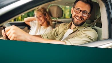 Przedstawia kobietę i mężczyznę w samochodzie 