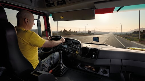 kierowca ciężarówki prowadzący pojazd na pustej drodze